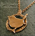 Circle shaped pendant featuring a hand sculpted wren