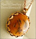 Faux amber cabochon set in a pink bronze bezel pendant