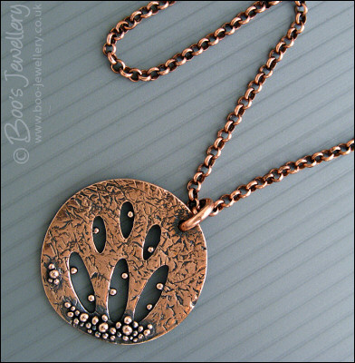 Textured copper pendant drizzled with tiny raindrops