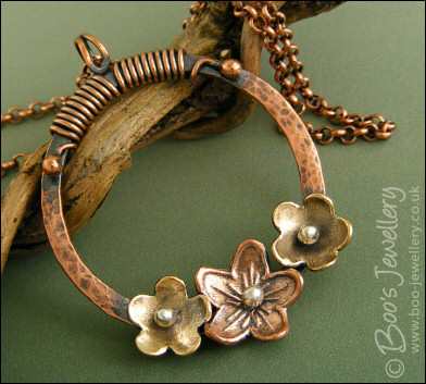 Hammered copper ring with bronze and copper flowers