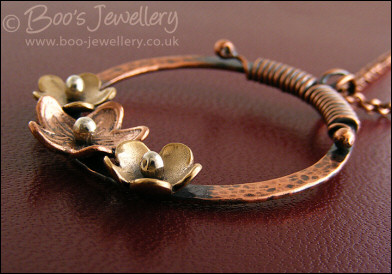Hammered copper ring with bronze and copper flowers