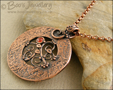 Round copper pendant with filigree centre and cubic zirconia gemstone