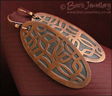 Oval shaped etched copper earrings with retro geometric design