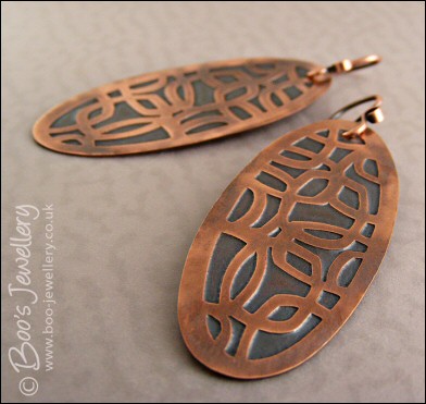 Oval shaped etched copper earrings with retro geometric design