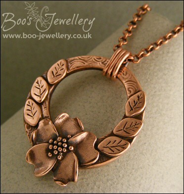 Circle pendant with sculpted wild rose