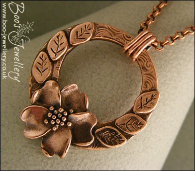 Circle pendant with sculpted wild rose