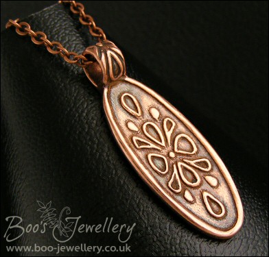 Oval copper pendant with hand drawn geometric design