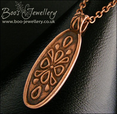 Oval copper pendant with hand drawn geometric design