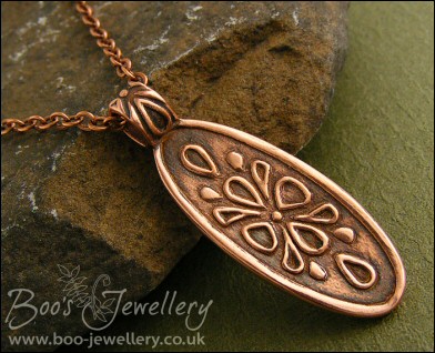 Oval copper pendant with hand drawn geometric design