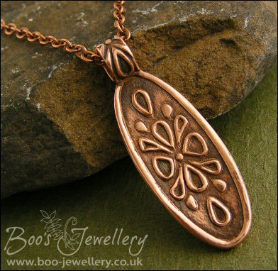 Oval copper pendant with hand drawn geometric design