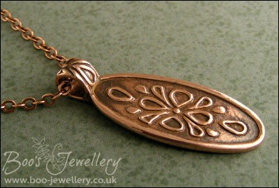 Oval copper pendant with hand drawn geometric design