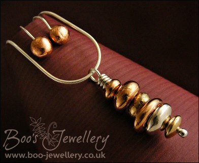 Mixed metal pebble stack pendant on silver chain with matching earrings