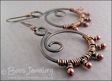 Oxidised copper swirl earrings wrapped with rosy copper buds