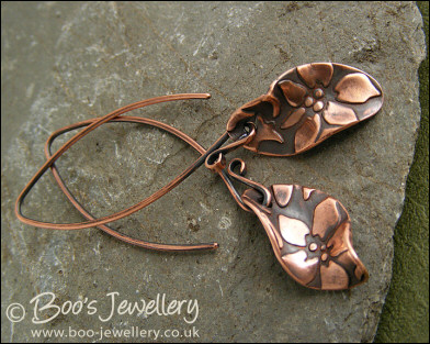 Antiqued copper earrings with flower charms and long feature earwires