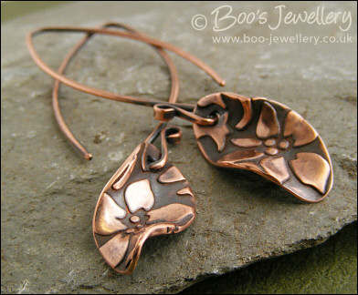 Antiqued copper earrings with flower charms and long feature earwires