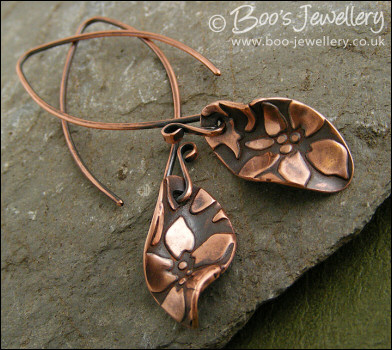 Antiqued copper earrings with flower charms and long feature earwires