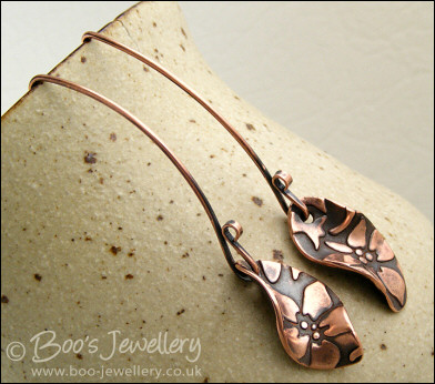 Antiqued copper earrings with flower charms and long feature earwires