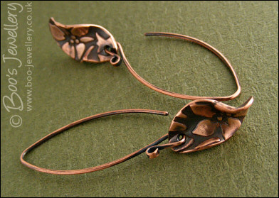 Antiqued copper earrings with flower charms and long feature earwires