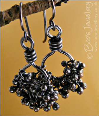 Earrings featuring dark clusters of molten copper