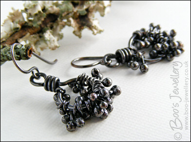 Earrings featuring dark clusters of molten copper