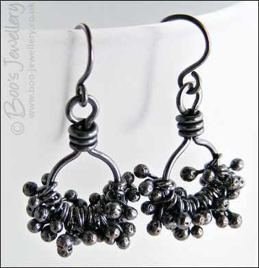 Earrings featuring dark clusters of molten copper