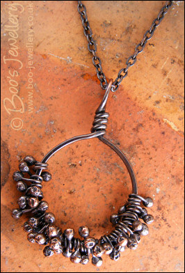 Necklace featuring dark clusters of molten copper