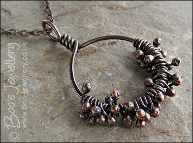 Necklace featuring dark clusters of molten copper