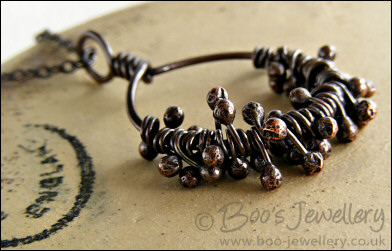 Necklace featuring dark clusters of molten copper