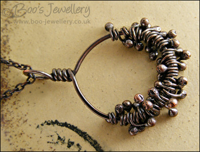 Necklace featuring dark clusters of molten copper