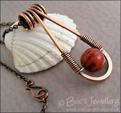 Teardrop shaped antiqued copper and red coral pendant