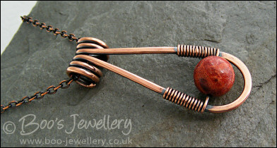 Teardrop shaped antiqued copper and red coral pendant