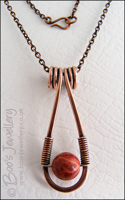 Teardrop shaped antiqued copper and red coral pendant