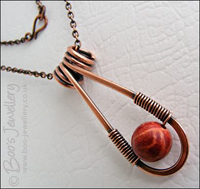 Teardrop shaped antiqued copper and red coral pendant