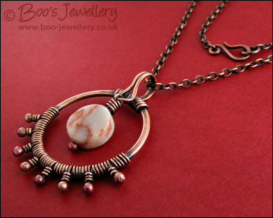 Antiqued copper circle pendant, bud wrapped and with spider web jasper