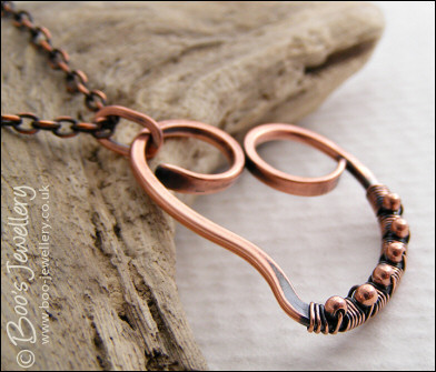 Curly antiqued copper heart wrapped with beads