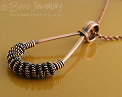 Antiqued copper teardrop pendant with spiralled coils