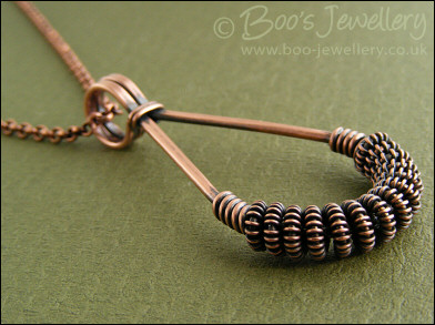 Antiqued copper teardrop pendant with spiralled coils