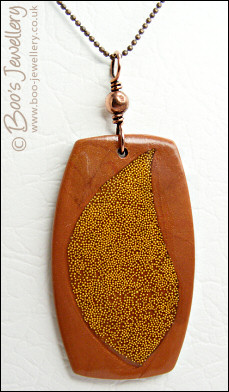 Polymer clay pendant inlaid with tiny gold balls