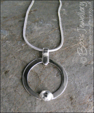 Hammered silver circle pendant with silver pebble