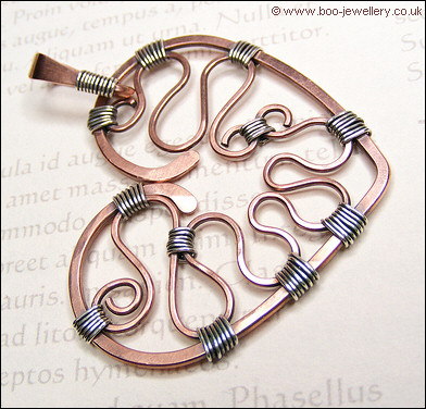 Hammered copper heart with silver wrapping on a chain