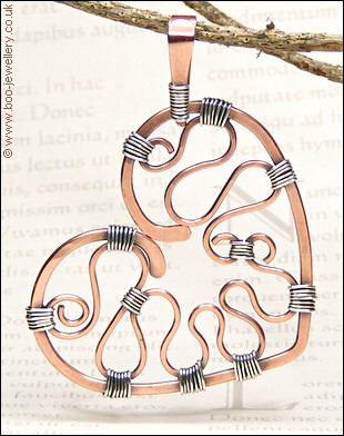 Hammered copper heart with silver wrapping on a chain