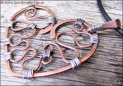 Hammered copper heart with silver wrapping on a chain