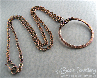Hammered copper circle pendant with tendril bail
