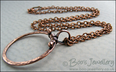 Hammered copper circle pendant with tendril bail